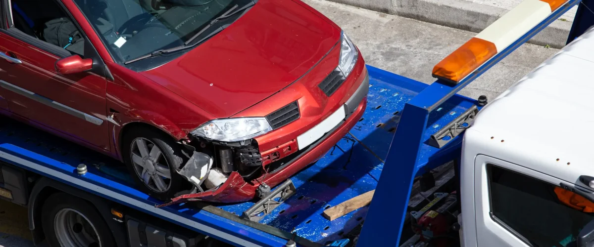 A crashed car loaded on a tow truck.